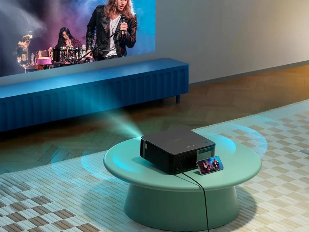 Projektor YABER KS2 Plus - Domowe kino premium, projektor stojący na stoliku wyświetlający obraz na ścianie