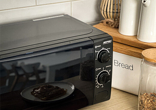 Zbliżenie na pokrętła kuchenki mikrofalowej MPM-20-KMM-12 ustawionej na kuchennym blacie.