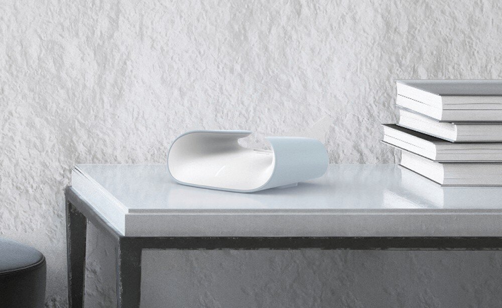 Router D-LINK M60 Aquila PRO AX6000 umieszczony na białym blacie, obok stosu książek, w minimalistycznym wnętrzu