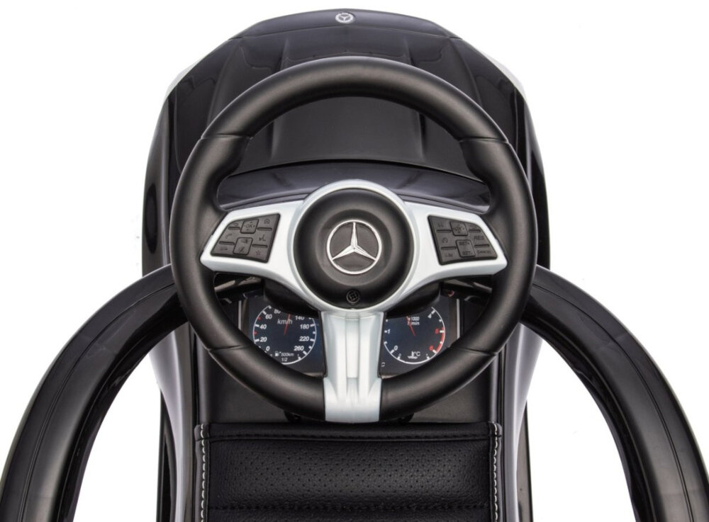 Jeździk MILLY MALLY Mercedes Benz C-Class Deluxe Czarny zbliżenie na kierownicę widok z góry białe tło trójramienna kierownica płynne skręcanie klakson i dźwięk silnika prosty mechanizm kierowniczy uczy malucha podstaw manewrowania i koordynacji ręka–noga wspiera koncentrację rozwija zdolność oceny kierunku