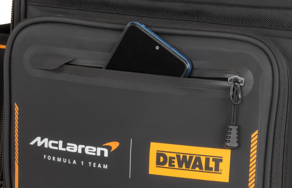Plecak monterski DEWALT McLaren F1 DWST60122-1 zbliżenie na przód plecaka widoczna kieszonka na zamek w kieszonce telefon główna komora otwiera się szeroko szybki dostęp do zawartości jasna żółta tkanina wyściełająca wnętrze dobra widoczność narzędzi zamek błyskawiczny z funkcją szybkiego zamykania