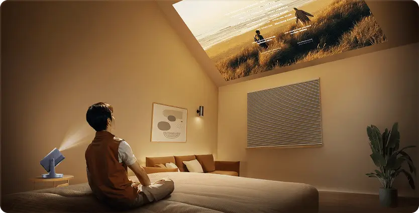 Projektor wyświetla film na skośnym suficie. Obok grafika z zakresem regulacji uchwytu urządzenia: 360° i 135°.