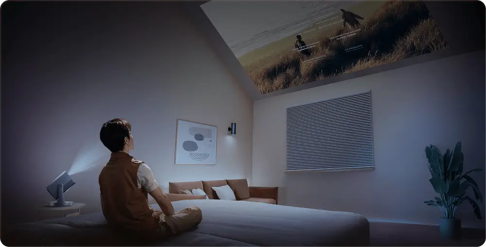 Projektor wyświetla film na skośnym suficie. Obok grafika z zakresem regulacji uchwytu urządzenia: 360° i 135°.