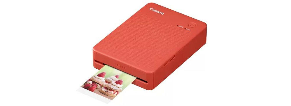 Drukarka CANON Selphy Square QX20 Druk w kolorze, Wi-Fi Biały urządzenie na białym tle od przodu pod kątem z wychodzącym zdjęciem wbudowany akumulator jedno pełne ładowanie do 20 arkuszy swoboda