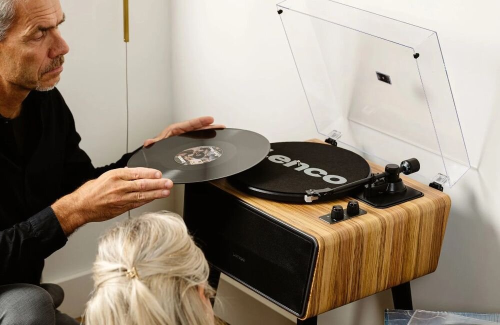 Gramofon LENCO LS-570OK cztery głośniki 70W RMS wbudowane nagłośnienie, osoba umieszczająca płytę do gramofonu