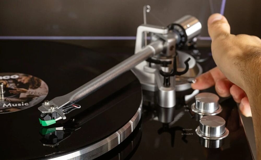 Gramofon LENCO LBT215BK Bluetooth 5.2 bezprzewodowe połączenie głośniki słuchawki, kadr na gramofon, ręka obsługująca ramię