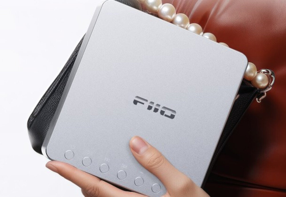 FIIO DM13 kompaktowy odtwarzacz CD ESP stabilny dźwięk, osoba trzymająca odtwarzacz w ręku