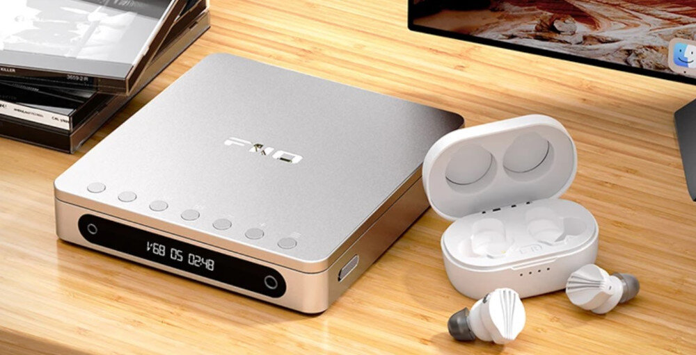 FIIO DM13 BT odtwarzanie w pętli ulubione utwory, odtwarzacz leżący na drewnianym blacie wraz z etui ładującym oraz słuchwkami dokanałowymi