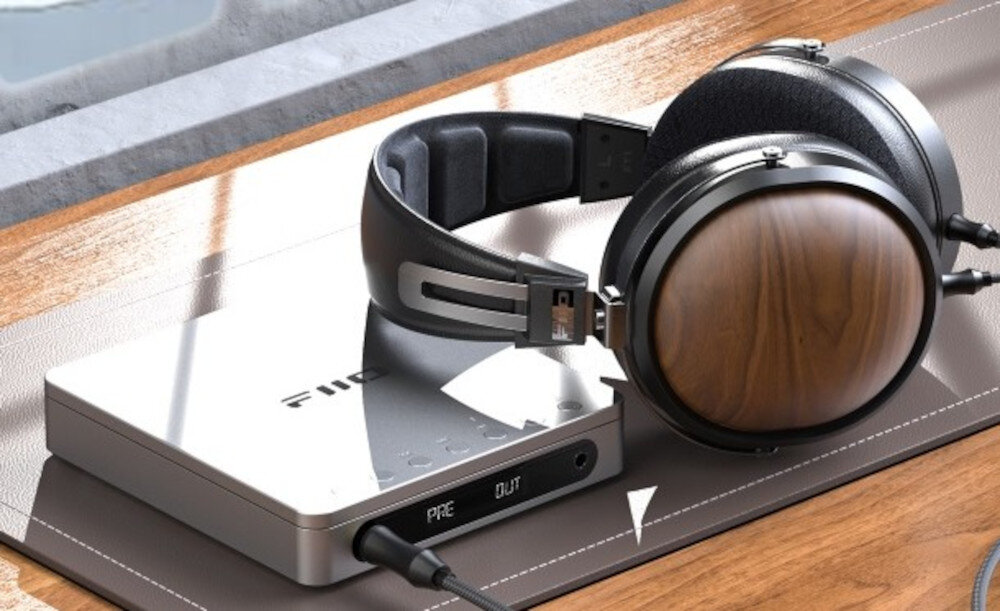 Przenośny odtwarzacz CD FIIO DM13 wysokiej jakości audio, odtwarzacz cd leżący na biurku obok słuchawek