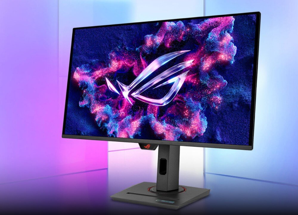 Monitor ASUS ROG Strix XG27ACDNG Monitor z wyświetlonym dynamicznym logo na kolorowym tle w odcieniach niebieskiego i różowego, ustawiony na biurku w jasnym pomieszczeniu z pastelowym podświetleniem, opis