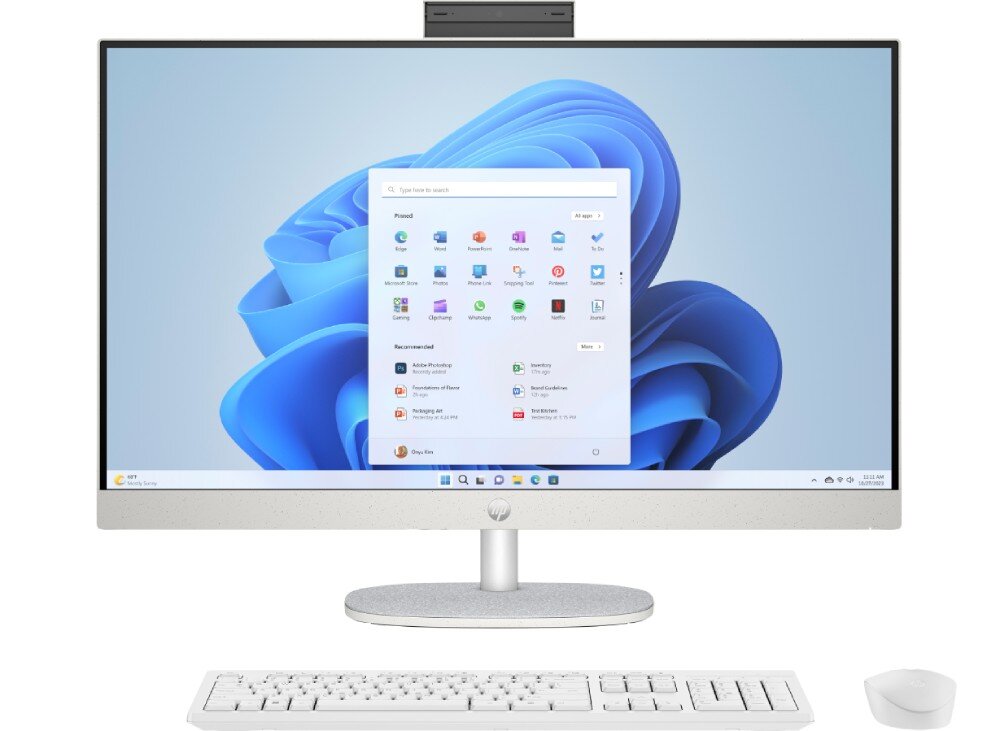 Komputer HP All-in-One 27-cr0222nw Widok na ekran komputera z uruchomionym systemem z niebieskim tłem oraz zestawem ikon aplikacji, klawiaturą i myszą na pierwszym planie, materiały, recykling