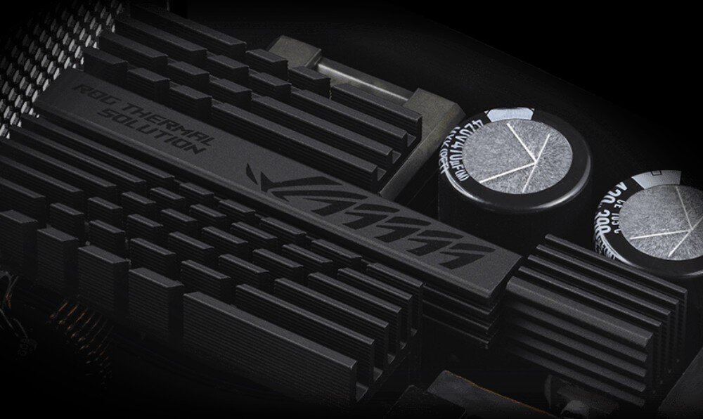 Zasilacz ASUS ROG Strix 1000W Wnętrze zasilacza komputerowego pokazujące czarne radiatory chłodzące z żebrowaniem oraz dwa duże kondensatory