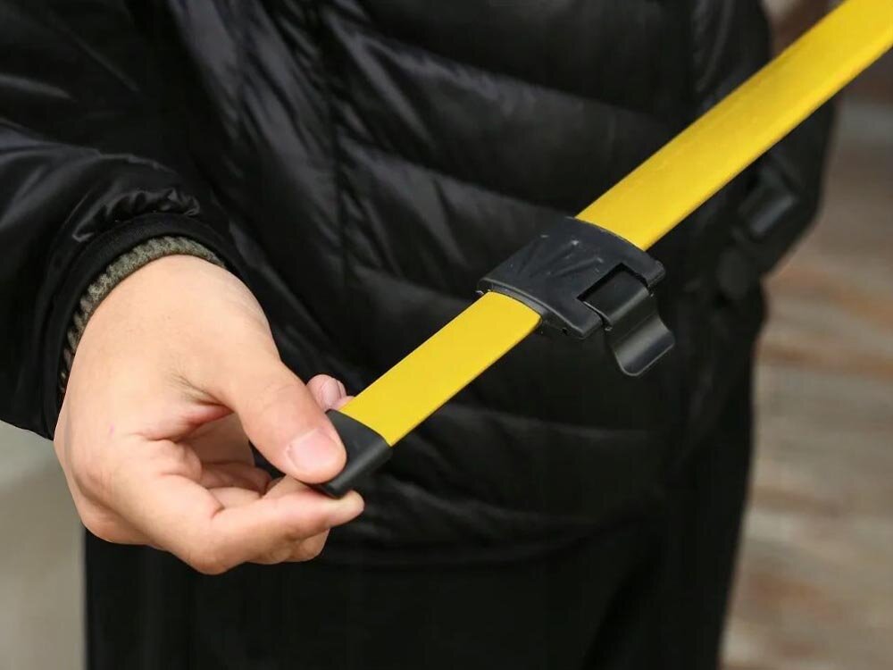 Statyw do poziomicy EXTRALINK EX.21267, kompatybilny, żółty, lasery, montaż, dłoń trzyma jedną z nóg statywu