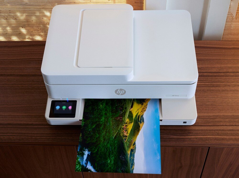 Urządzenie wielofunkcyjne HP ENVY 6520e drukarka stojąca na biurku z wychodzącym wydrukiem opis