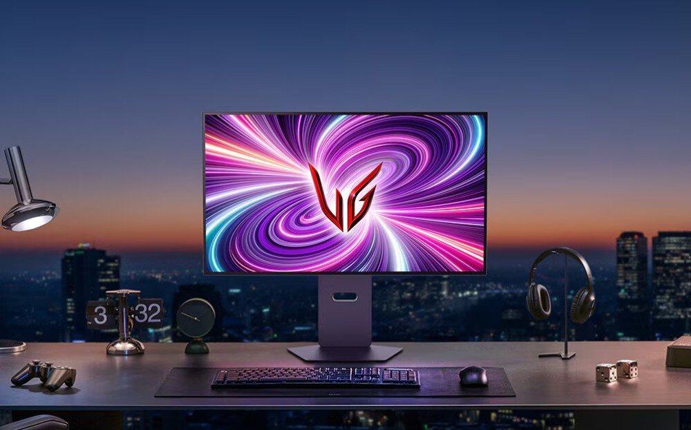 Monitor LG UltraGear 32GS95UV-B.AEU Monitor ustawiony na biurku przy oknie z widokiem na nocne miasto. Na ekranie dynamiczna grafika z logo 'UG'. Obok znajdują się słuchawki, klawiatura, mysz i zegary, kolory, dokładność, odwzorowanie barw, kontrast