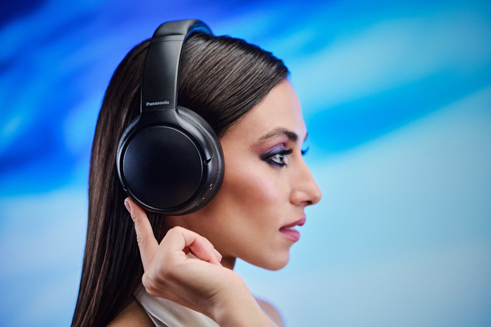 Słuchawki nauszne PANASONIC RB-M600BE-C - Energia płynąca z basu, XBS Deep (eXtra Bass System), osoba z założonymi słuchawkami nausznymi na błękitnym tle