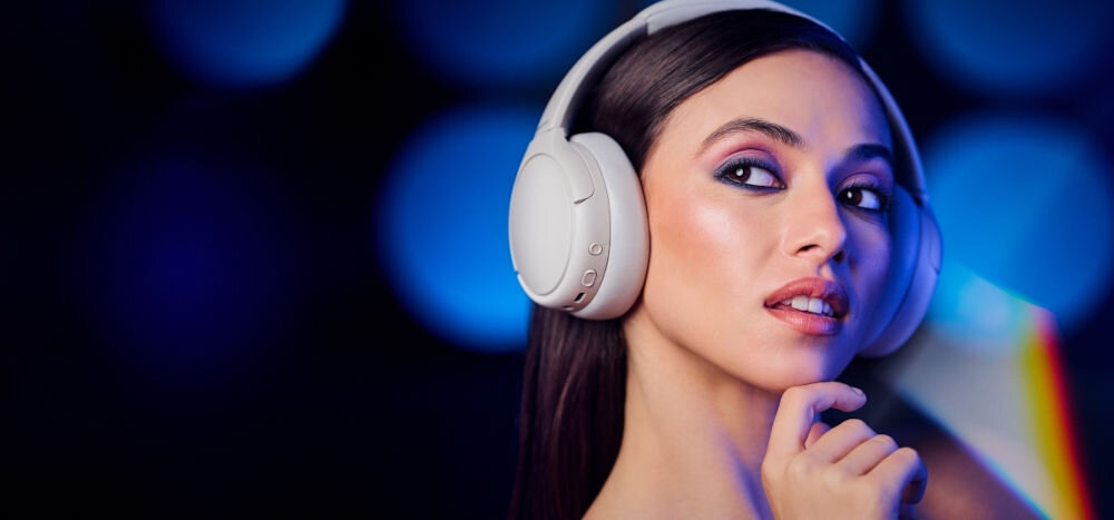 Słuchawki nauszne PANASONIC RB-M600BE-C - Komfort, który trwa godzinami, Miękki pałąk, nauszniki, osoba z założonymi słuchawkami nausznymi na ciemnym tle