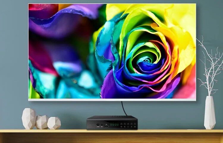 Dekoder EXTRALINK DVB-T2 HEVC H.265 wygodny odbiór telewizji naziemnej, dekoder postawiony na komodzie pod zawieszonym telewizorem