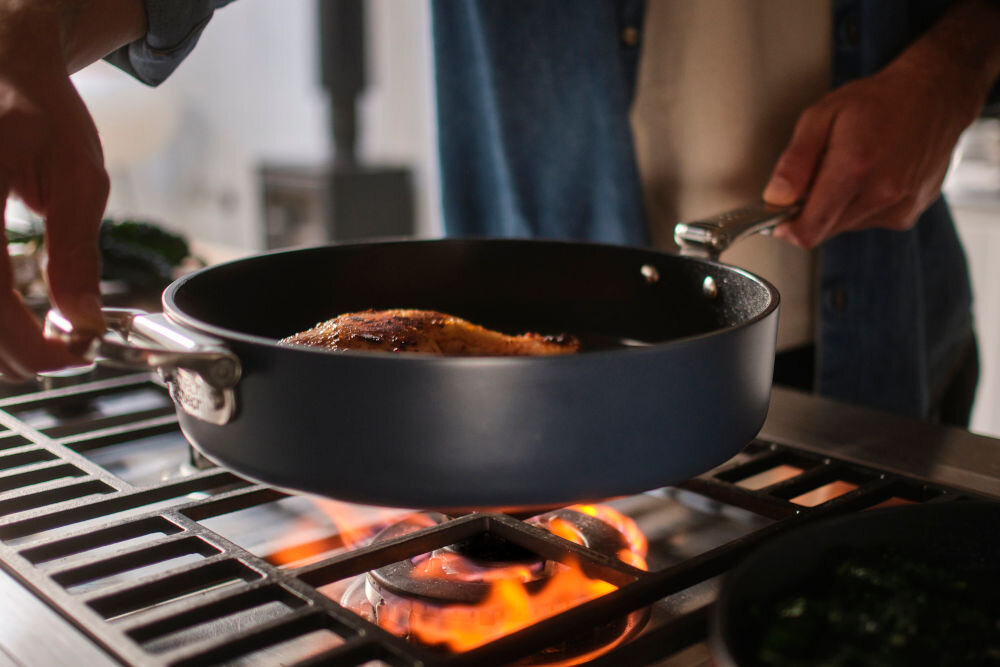 JJ-Patelnia 28cm ze składanym uchwytem+pokr. Space patelnia ustawiana na palniku potrawa w środku niebieska powierzchnia srebrne uchwyty 