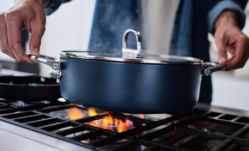 JJ-Garnek wysoki 25cm ze skł. uchwytami+pokr.Space osoba chwyta na srebrne uchwyty i stawia garnek na palniku kuchenka gazowa ceramiczna indukcyjna do używania w piekarniku bezpieczne wykorzystanie w piekarniku do 32 stopni wszechstronność funkcjonalność w każdej kuchni różnorodne metody gotowania solidna konstrukcja elegancki wygląd dla miłośników kulinariów praktyczne rozwiązania 