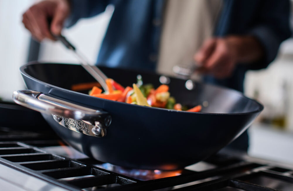 JJ-Wok 32cm ze składanymi uchwytami Space srebrne uchwyty niebieska powłoka warzywa na patelni osoba miesza potrawę z solidnego aluminium nieprzywierająca powłoka ceramiczna optymalne warunki nie zawiera szkodliwych substancji PTFE, PFAS, PFOA, ołów ani kadm bezpieczna dla zdrowia średnica 32 cm duże porcji potraw do kulinarnej eksploracji