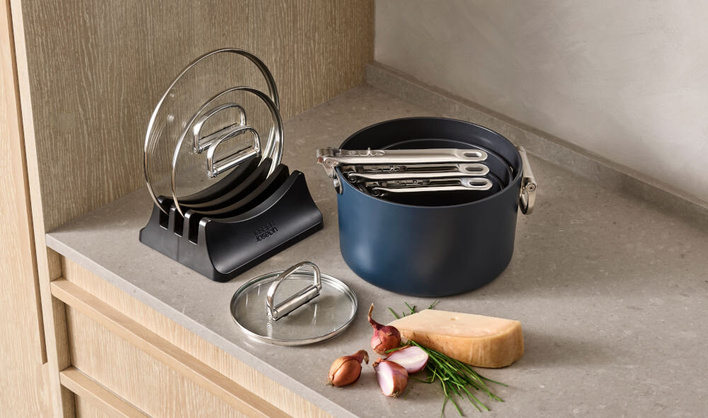 JJ-Zestaw rondli ze skł.uchwytami +pokrywk++ Space do każdej kuchni rondeli włożone jeden na drugim schowane uchwyty rondle stoją na blacie pokrywki na podstawce niebieska powłoka