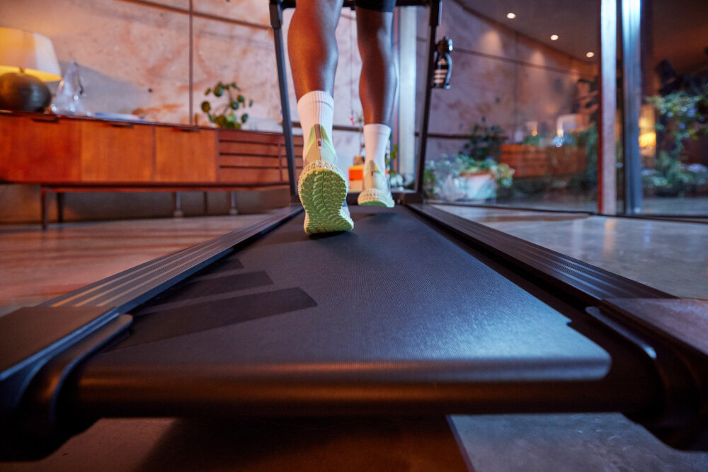 Bieżnia elektryczna ADIDAS T-24C 1470W 18km-h pokój zbliżenie na pas biegowy w tle komoda okno na taras technologia amortyzacji zmniejsza wstrząsy i odciąża stawy powierzchnia do biegania 130 × 45 cm więcej swobody ruchu