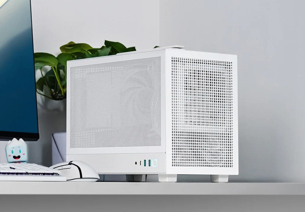 Obudowa DEEPCOOL CH160 Mesh Komputer w białej obudowie na biurku, widoczny pod kątem od strony bocznego panelu z siatki, przez który widać zarys podzespołów