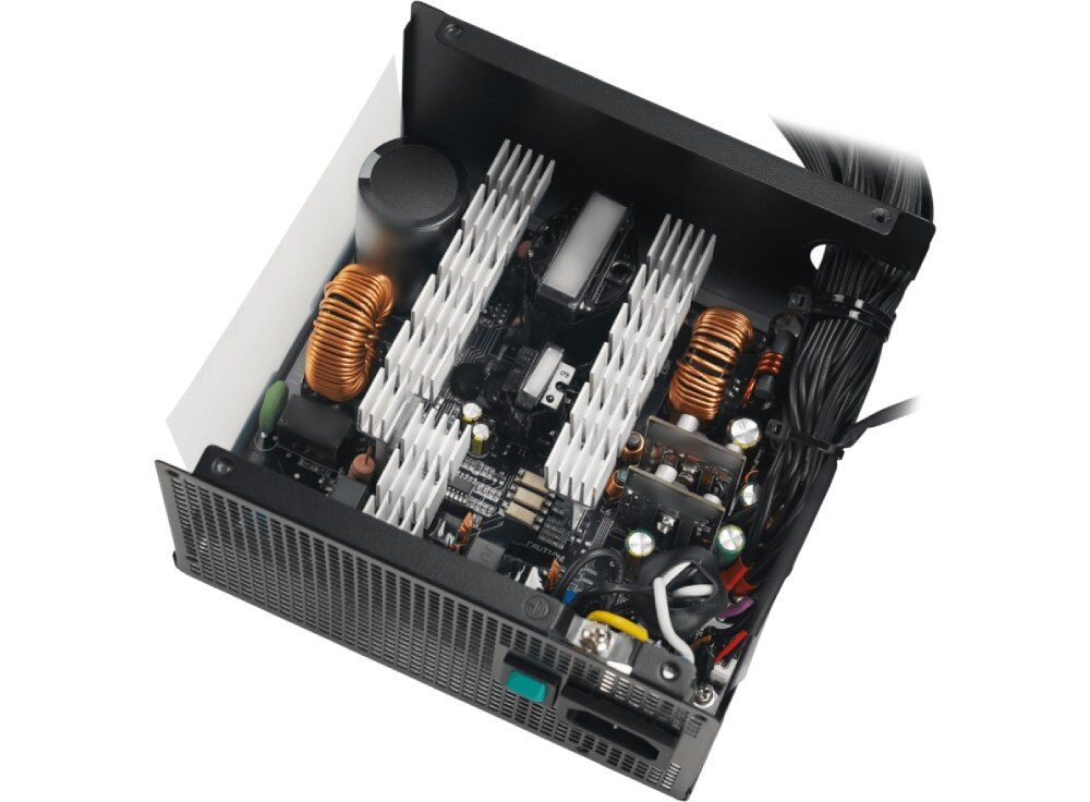 Zasilacz DEEPCOOL PL550D Wnętrze zasilacza komputerowego po zdjęciu obudowy ukazujące komponenty elektroniczne, miedziane cewki, białe radiatory oraz kondensatory na czarnej płytce drukowanej
