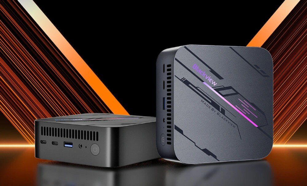 Komputer BLACKVIEW MP100 Dwa małe komputery w kolorze grafitowym stoją obok siebie na tle pomarańczowych pasów świetlnych, z widocznym podświetlanym wzorem na obudowie, opis