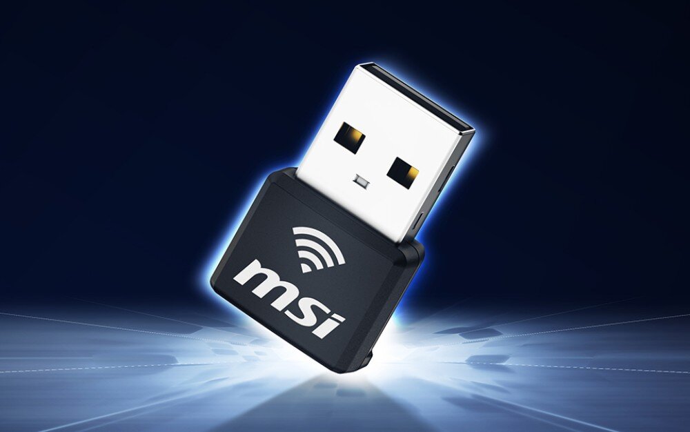 Karta sieciowa MSI AX1800 Nano GUAX18N Czarny adapter sieciowy USB z białym napisem 'msi' oraz symbolem fal radiowych, przedstawiony pod kątem na ciemnym tle z jasnym rozbłyskiem