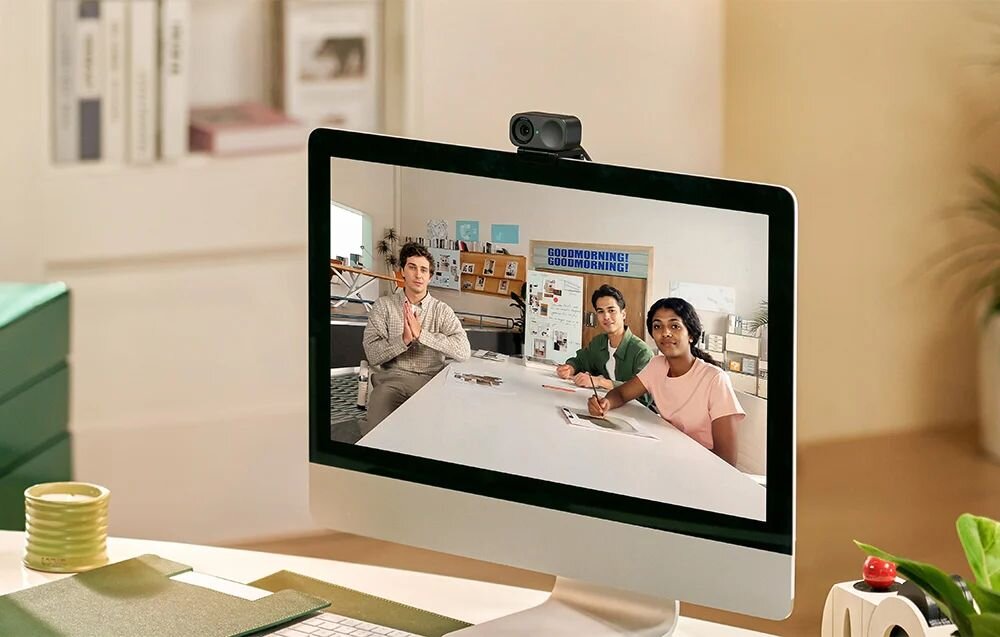 insta360 Link 2C insta360 Link 2C technologię Phase Detection Auto Focus (PDAF), autofokusa PDAF  - Monitor komputera z widokiem trzech osób uczestniczących w spotkaniu online w jasnym biurze.