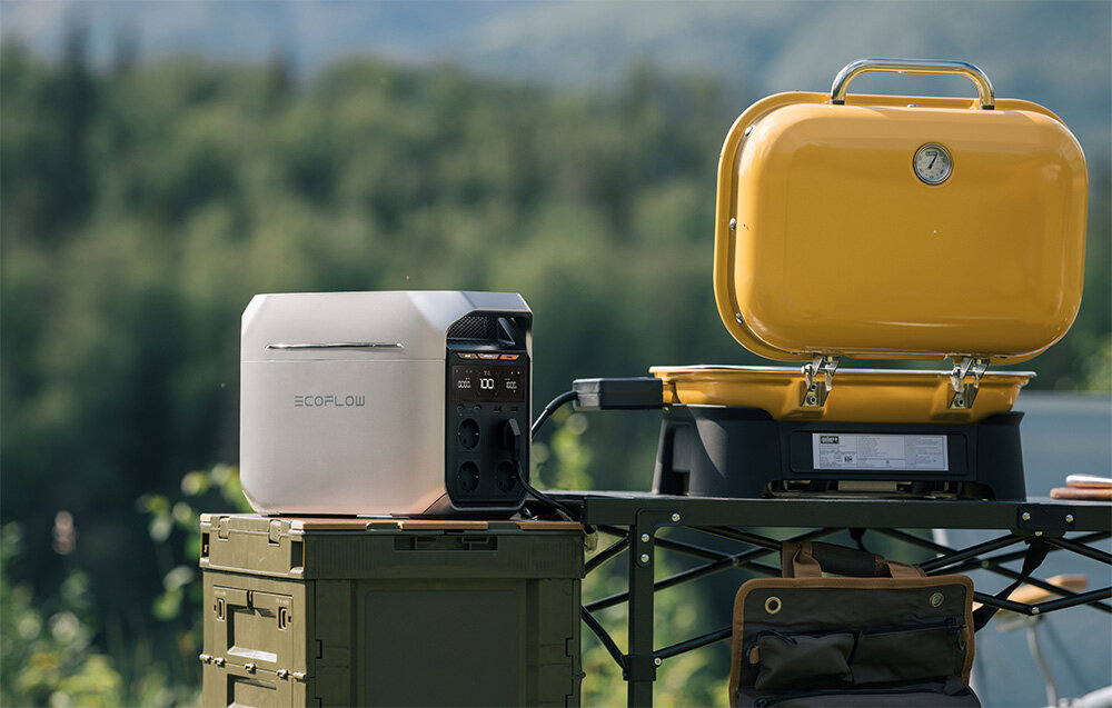 Przenośna stacja zasilania EcoFlow DELTA 3, Gotowośc na medal, Stacja stoi na stoliku na terenie biwakowym podczas wyprawy