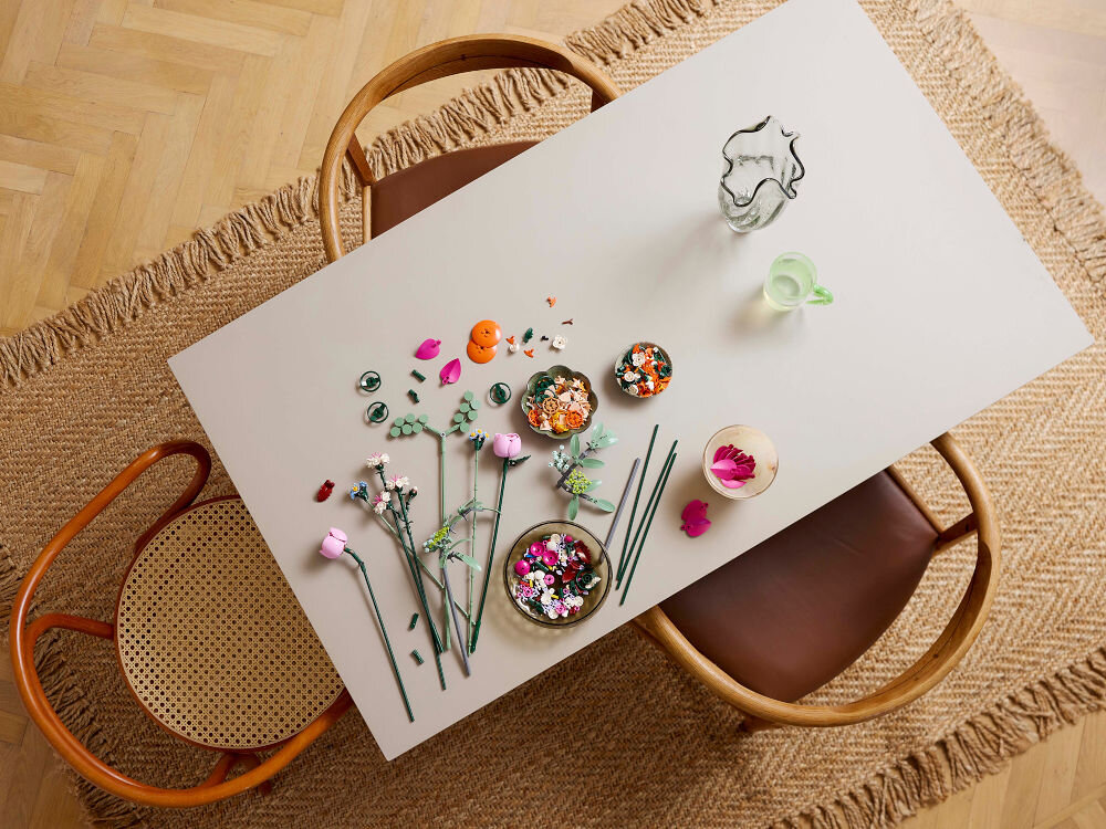 LEGO 10342 ICONS Botanicals Piękny bukiet różowych kwiatów klocki rozsypane na stole stokrotki chabry róże