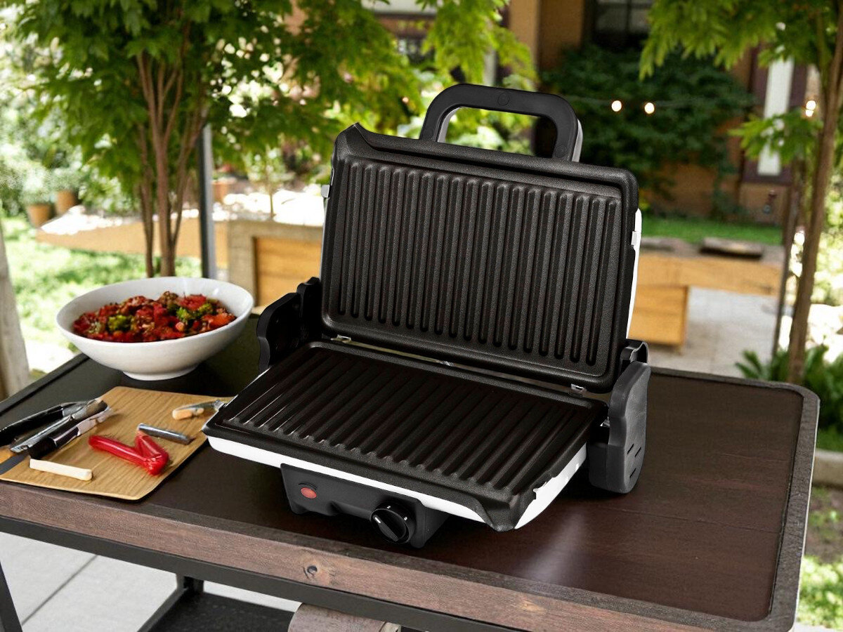 Grill elektryczny TEFAL GC2050 Minute, tryby, praca, pokrywa, tryby, grill stoi na blacie drewnianym w ogródku