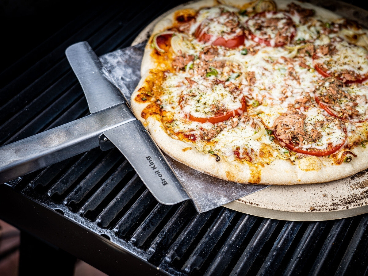 Kamień do pizzy BROIL KING 33 cm, grill, pizza, włoski, smak, Pizza z salami, pomidorami i serem na czarnej patelni na ruszcie grilla Broil King, z łopatką pizza peel.