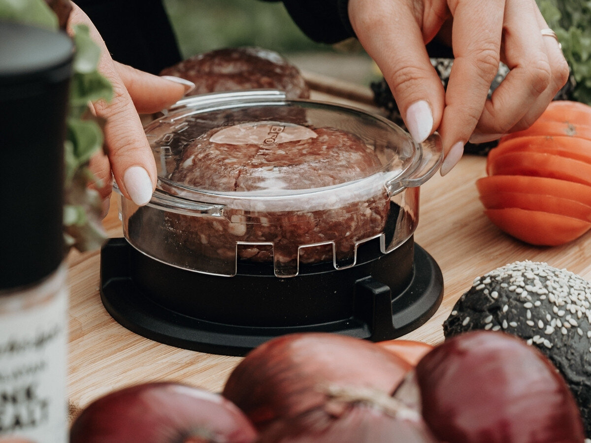 Prasa do hamburgerów BROIL KING 62475, nacisk, wygoda, formowanie, mięso, osoba operuje pokrywą praski do hamburgerów