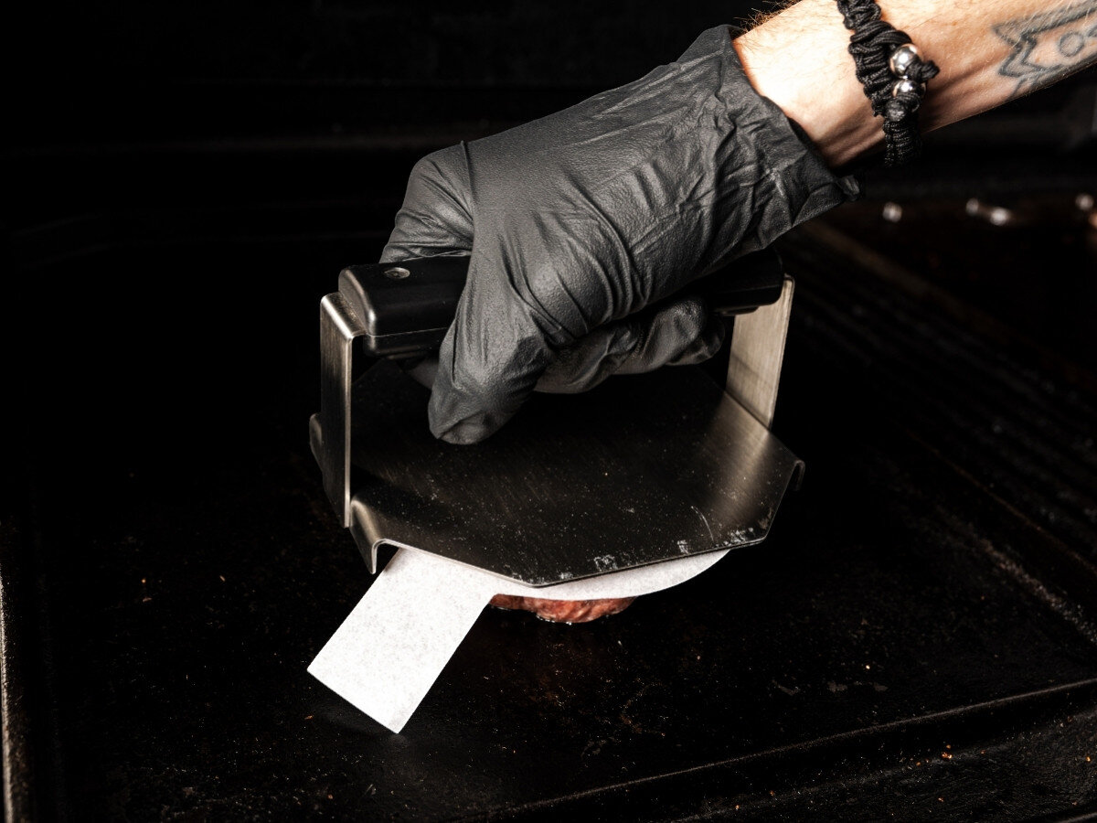 Papier do praski BROIL KING 62470 (100 szt.), papier, mięso, przywieranie, burgery, Praso-szpachelka do burgerów Broil King z białym papierem wciska burgera na płycie grilla.