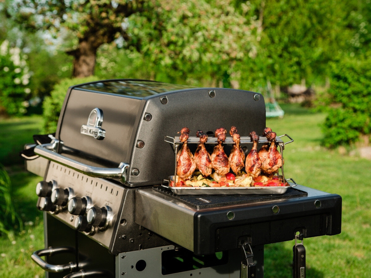 Wieszak na podudzia BROIL KING 64152, wieszak, podudzia, grill, cyrkulacja, Uchwyt rotacyjny Broil King na grillu z udkami kurczaka i warzywami w ogrodzie na trawie.