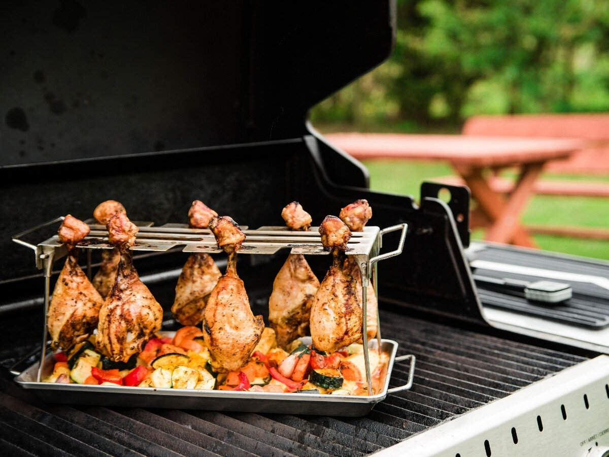 Wieszak na podudzia BROIL KING 64152, brytfanna, aromaty, skórka, soczystość, Grill Broil King z otwartą pokrywą, uchwyt rotacyjny z udkami kurczaka i ziemniakami w ogrodzie.