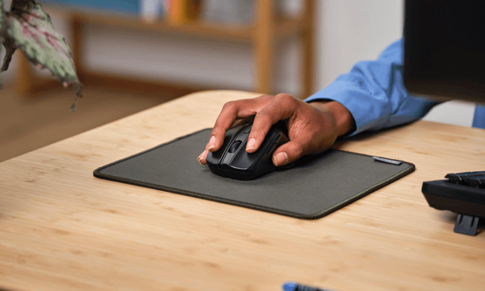 TRUST Nito Silent - mysz na podkładce na biurku, widoczna ręka na niej
