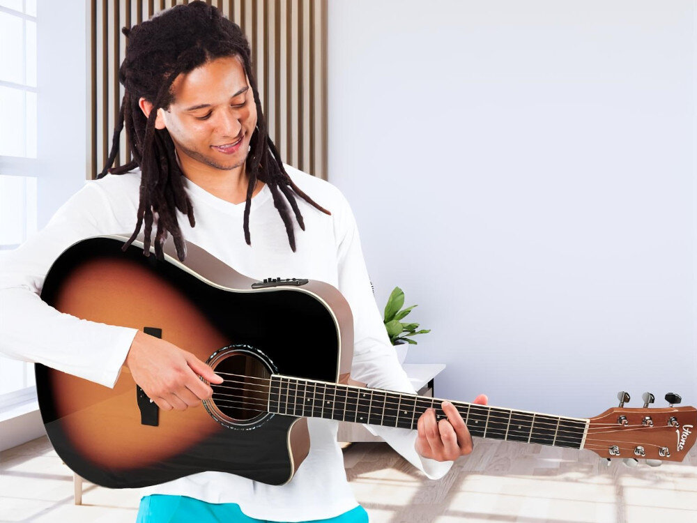 Gitara elektroakustyczna V-TONE Veag1 CE VS 4- Głośne brzmienie, lekka forma, mężczyzna grający na gitarze w pomieszczeniu
