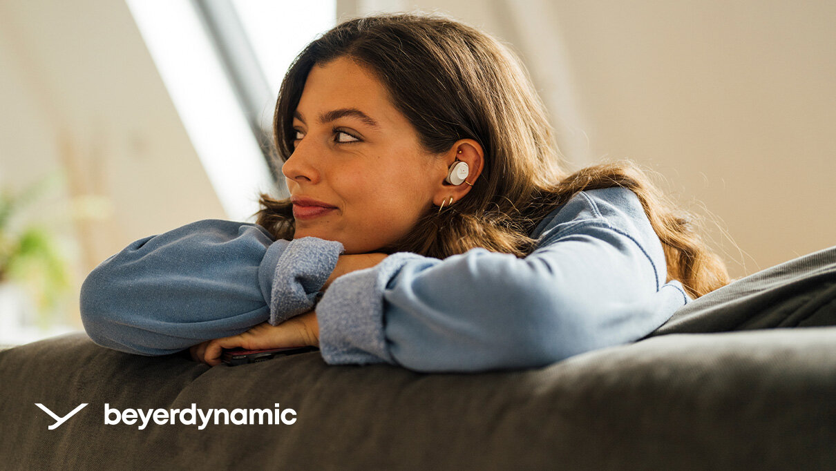 beyerdynamic AMIRON 300 osoba w słuchawkach w lewym dolnym rogu marka