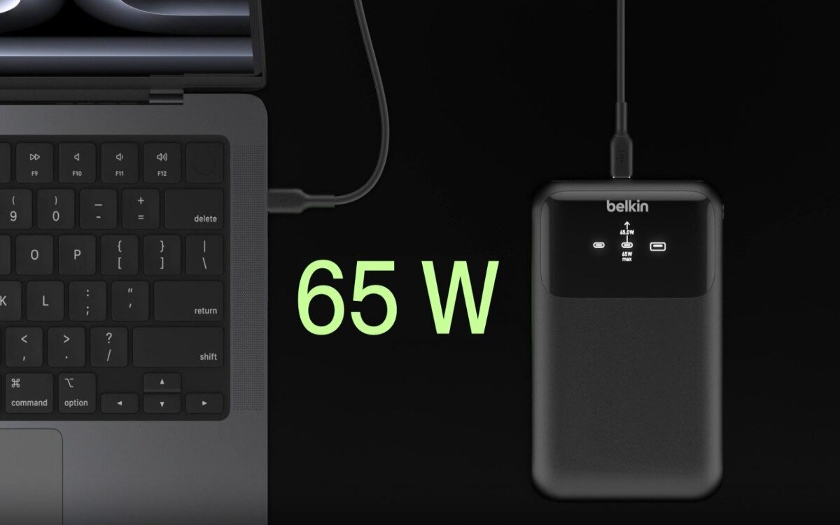 Power bank BELKIN podpięty do laptopa, pomiędzy power bankiem a laptopem widoczny jest napis '65 W'.