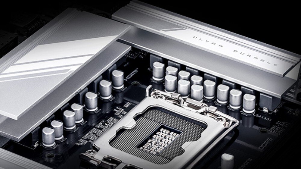 Płyta główna GIGABYTE B860 DS3H WiFi6E Zbliżenie na górną część płyty głównej, skupione na gnieździe procesora oraz rzędzie srebrnych kondensatorów. Nad nimi znajdują się metalowe radiatory z napisem 'ULTRA DURABLE'