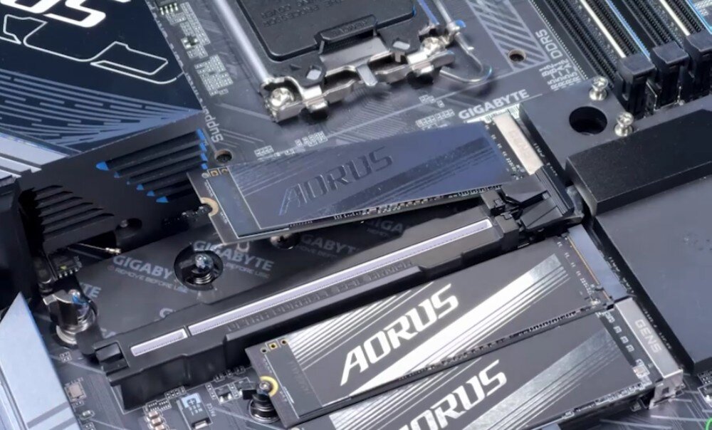 Płyta główna GIGABYTE B860 Gaming X WiFi6E Płyta główna z zamontowanymi trzema dyskami SSD M.2 marki AORUS, pokazana podczas instalacji jednego z dysków, interfejs PCIe 5.0, gniazda M.2