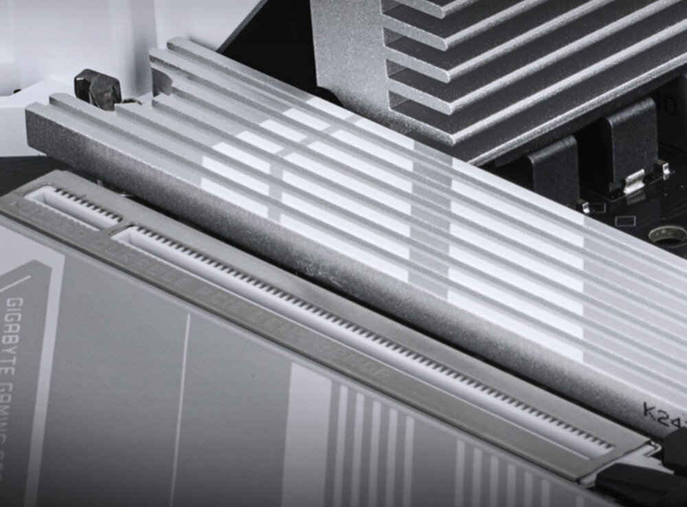 Płyta główna GIGABYTE B860 Gaming X WiFi6E Zbliżenie na srebrne złącze PCIe płyty głównej oraz radiator z wyżłobieniami w tle, chłodzenie, radiatory, temperatura