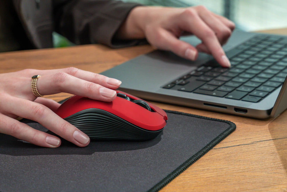 Mysz XQUANTUM WM503R Silent Czerwony widok bokiem połozona na czasrnej podkładce na biurku łączność 2,4 HGz zasięg do 10 metrów bez kabli