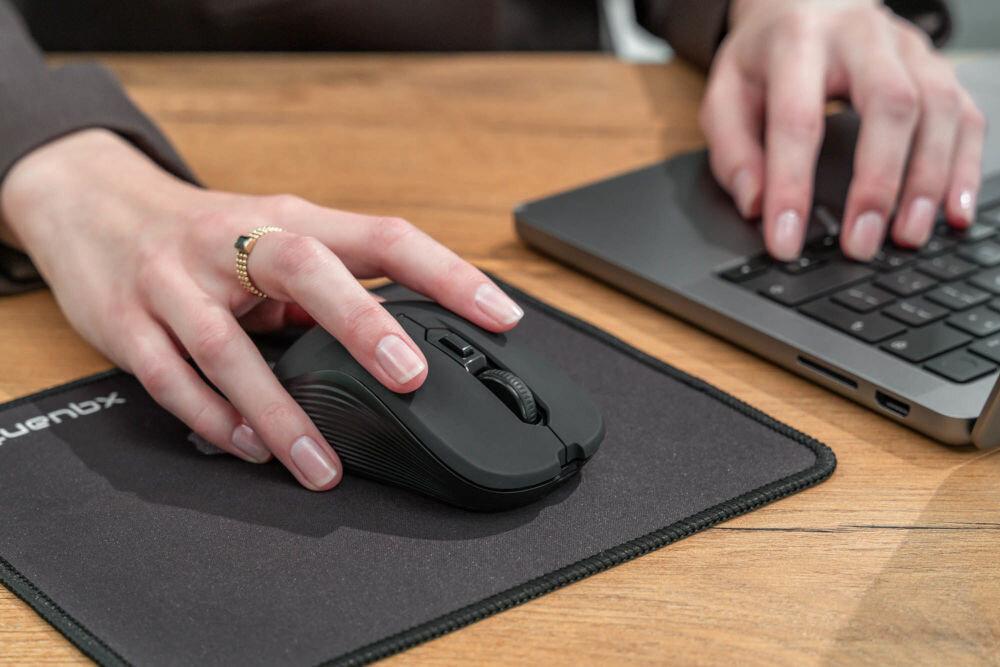 Mysz XQUANTUM WM503R Silent Czarny widok bokiem połozona na czasrnej podkładce na biurku łączność 2,4 HGz zasięg do 10 metrów bez kabli