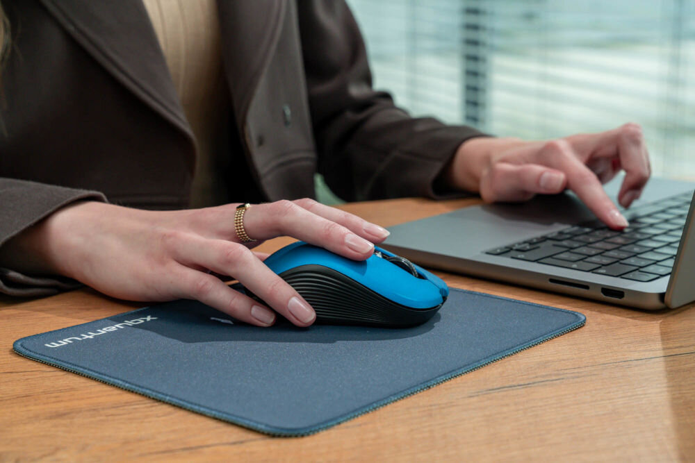 Mysz XQUANTUM WM503R Silent Szary widok bokiem połozona na czasrnej podkładce na biurku łączność 2,4 HGz zasięg do 10 metrów bez kabli